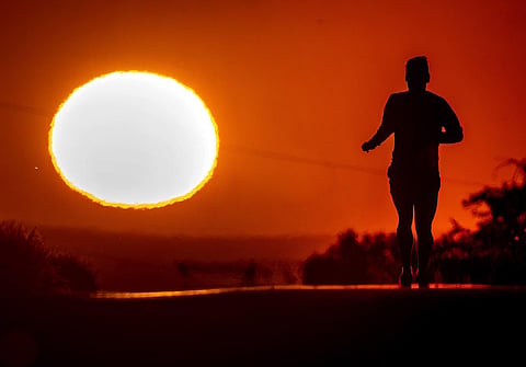 A blanket of hot air stretching from the Mediterranean to the North Sea is giving much of western Europe its first heat wave of the summer, with temperatures forecast to top 30 degrees Celsius. Meteorologists say the unusually early heat wave is a sign of what's to come as global warming continues, moving up in the calendar the extreme temperatures that Europe would previously have seen only in July and August. A man runs up a hill on a small road in Frankfurt, Germany, as the sun rises on June 17, 2022. (Photo | AP)