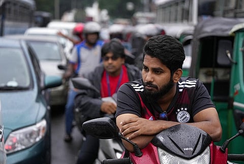 People wait in a long queues to buy fuel for their vehicles at a filling station in Colombo, Sri Lanka. (Photo| AP)