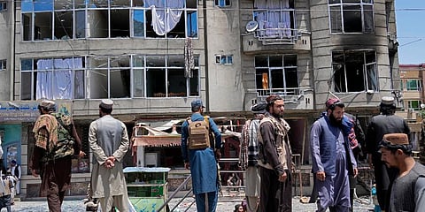 Taliban fighters stand guard at the site of an explosion in front of a Sikh temple in Kabul, Afghanistan, Saturday. (Photo | PTI)
