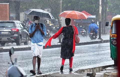 People caught in the rain at Banerji Road in Kochi on Wednesday. (Photo | A Sanesh, EPS)