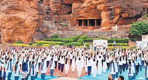 Students perform yoga in front of the famous cave temples in Badami of Bagalkot district on Tuesday | KPN
