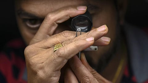 An artisan examining diamonds under a microscope. 