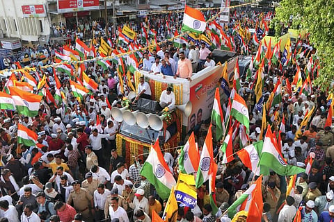 Delhi Chief Minister and AAP Convener Arvind Kejriwal waves at the supporters during the party's 'Tiranga Yatra' cum roadshow, in Mehsana. (Photo | PTI)