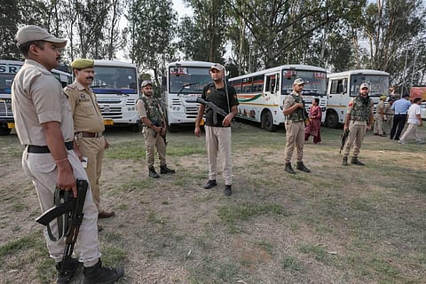 Security personnel stand guard as migrant Kashmiri Pandits leave for the annual 'Kheer Bhawani Mela' from Jammu. (Photo | PTI)