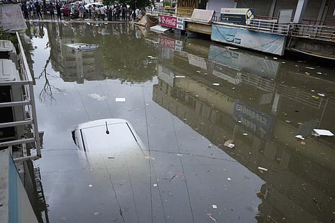 Vehicles seen submerged at a water logged shopping complex after heavy rain lashed Ahmedabad. (Photo | PTI)