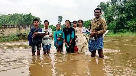 Students, accompanied by their parents, cross River Vegavathi to go to school in Saluru mandal. (Photo | EPS)
