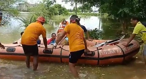 Odisha Fire Service personnel rescue a woman and her seven-day-old infant from flood waters on outskirts of Bhubaneswar. (Photo | Twitter/@mehta_asish)