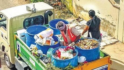 Sanitation workers collecting waste from residents 