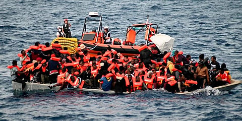 In this 2021 photograph, an overcrowded wooden boat packed with 99 migrants is approached by a tender of the humanitarian organization off the Libya coast. (Photo | AP)