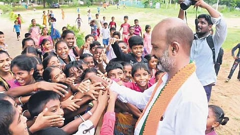 Telangana BJP chief Bandi Sanjay interacts with children at Bhongir on Wednesday during the third phase of his Praja Sangrama Yatra