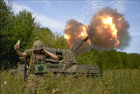 A Ukrainian soldier takes a selfie as an artillery system fires in the front line in Donetsk region, eastern Ukraine. (Photo | AP)