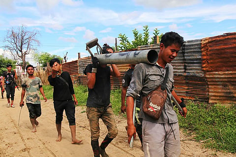 Anti-coup fighters walking with weapons in a township in Myanmar's northwestern Sagaing region. (Photo | AFP)