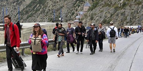 People, most of them Russians, walk after they crossed the border between Georgia and Russia at Verkhny Lars, in Georgia. (Photo | PTI)