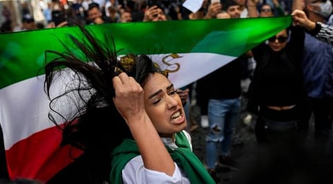 A woman shouts slogans next to an Iranian flag during a protest against the death of Iranian Mahsa Amini, outside Iran’s general consulate in Istanbul, Turkey, Wednesday, Sept. 21, 2022. (Photo | AP)