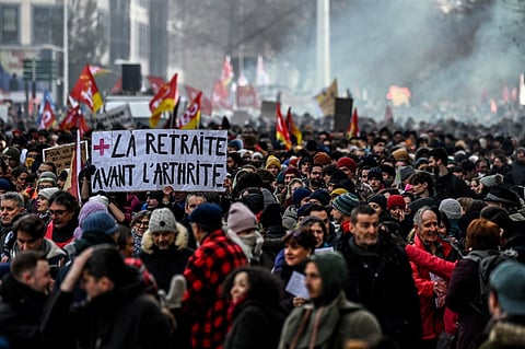 A protestor holds a placard which reads as 'retirement before arthritis' during a rally in Lyon, south-eastern France on January 19, 2023. (Photo | AFP)