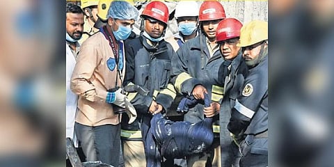 Fire officials and NDRF Teams carry the mortal remains of one of the three missing persons from the fire-ravaged Deccan Knitwear Sports Accessories complex in Nallagutta.  ​