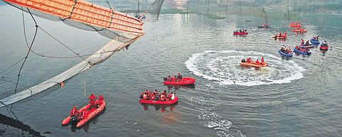 Search and rescue work on at the bridge collapse site in Morbi. (File photo | AP)