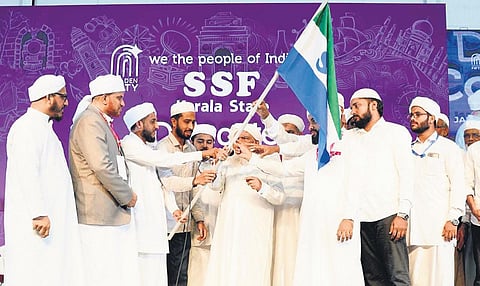 Samastha Kerala Jem-Iyyathul Ulama president E Suleiman Musaliyar handing over the SSF flag to the newly-elected office-bearers in Kozhikode on Sunday | Express