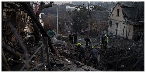 Workers inspect a crater in a residential street following a Russian attack in Kyiv. ( File photo | AP)