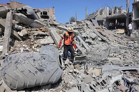 Palestinian rescuers search the rubble of destroyed buildings following an Israeli strike, as battles between Israel and Hamas militants continue in the city of Rafah.