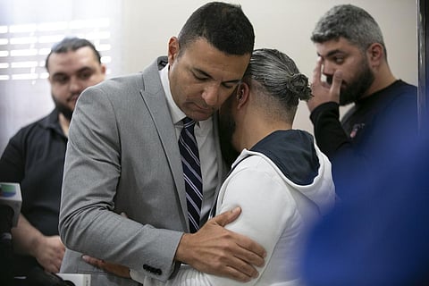 Ahmed Rehab, left, executive director of the Chicago chapter of the Council on American-Islamic Relations, embraces Odey Al-Fayoume, father of Wadea Al-Fayoume, 6.(AP)