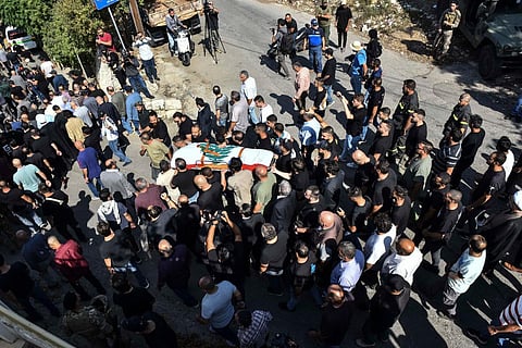 Mourners carry the flag-draped casket of Lebanese Reuters video journalist Issam Abdallah during his funeral in the village of El-Khiam on October 14, 2023. (Photo | AFP)