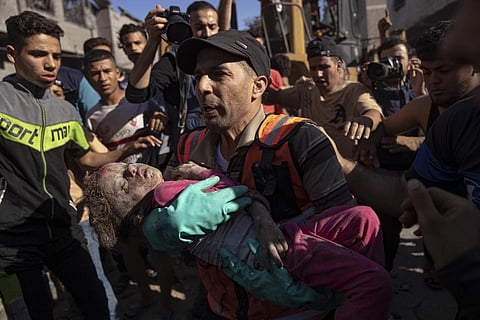 Palestinians evacuate a child after Israeli airstrike on Khan Younis, Gaza Strip, Tuesday, Oct 17, 2023. (Photo | AP)