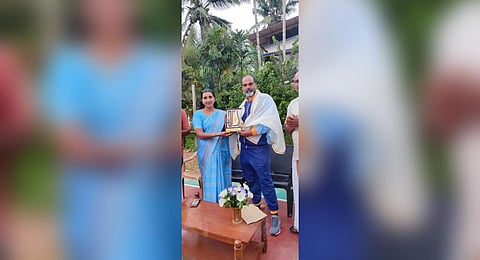 Kunhimangalam panchayat president Prarthana Vijayakumar hands over a memento to coach P Madhu at Allingal Brothers Sports and Arts Club