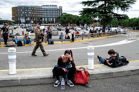 Passengers wait as a French soldier patrols outside the Toulouse-Blagnac Airport in Blagnac, southwestern France, on October 18, 2023. (Photo  |AFP)