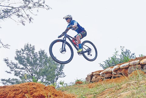 A cyclist practises gap jump (Downhill category) on Sunday ahead of the Asian  Mountain Bike Cycling Championship-2023 at Ponmudi in Thiruvananthapuram from October 26 to 29 | B P Deepu