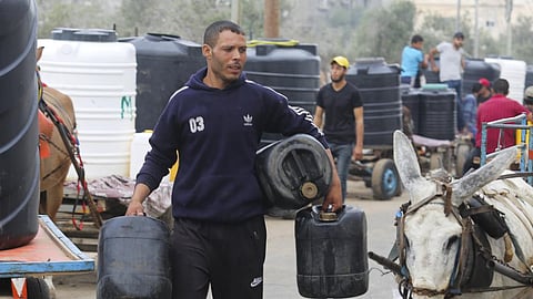 Palestinians arrive to collect drinking water during the ongoing Israeli bombardment of the Gaza Strip in Rafah, January 2024. 
