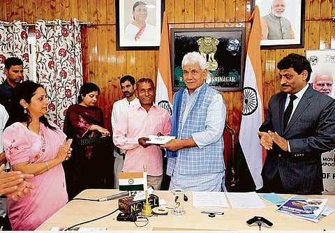 J&K Lieutenant Governor Manoj Sinha hands over a land allotment document to a beneficiary in Jammu | ANI