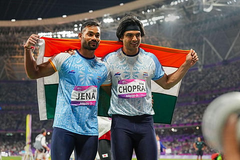 Neeraj Chopra (R) and Kishore Kumar Jena wave the national flag after securing gold and silver medal respectively in the Mens Javelin Throw Final event at the 19th Asian Games. (Photo | PTI)