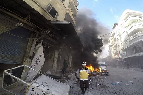 A Syrian White Helmet civil defense worker runs at the site where a shell struck in the outskirts of the northern town of Jisr al-Shoughour, west of the city of Idlib, Syria, on Oct. 5. (AP)