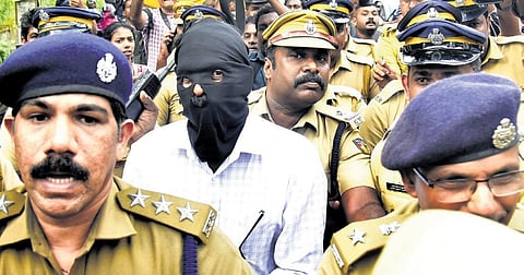 Police officials take Dominic Martin back to the police station after completing evidence collection at his property in Athani on Tuesday | A Sanesh