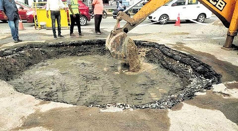 Soil filling in progress at the crater that developed on NH 66 on Saturday. ( Express)