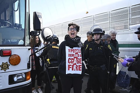Police officer detain a protester blocking the San Francisco-Oakland Bay Bridge while demonstrating against the APEC summit and  the Israel-Hamas war, Nov 16, 2023. (Photo | AP)