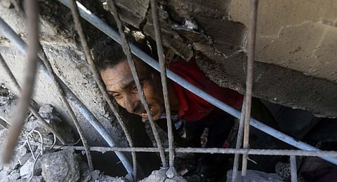 Palestinians look for survivors under the rubble of a destroyed building following an Israeli airstrike in Khan Younis refugee camp, southern Gaza Strip. (Photo | AP)