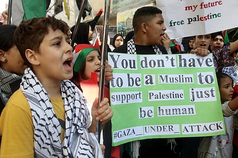 FILE - Palestinian children hold signs during a protest in support of Gaza, in the Ain al-Hilweh refugee camp, near southern Lebanese port city of Sidon on October 18, 2023. (Photo | AFP)