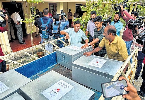 ED officials offloading the prosecution complaint from a goods carrier in front of the PMLA court in Kochi on Wednesday  | Express