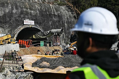 A rescue personnel stands near an entrance of the Silkyara under-construction road tunnel, during the final phase of a rescue operation, days after a portion of it collapsed in Uttarkashi. (AFP)