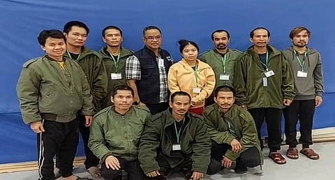 A Thai official (center) posing for a group photo with 10 released Thai hostages in Israel, after they were freed by Hamas. (Photo | AFP)