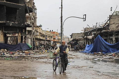 A Ravaged City: A Palestinian walks in Gaza City on Monday, Nov 27, 2023, on the fourth day of the temporary ceasefire between Hamas and Israel. 