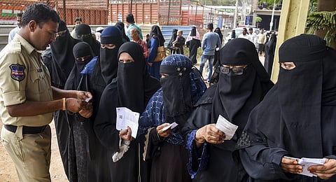 Voters get their identification cards checked as they arrive to cast their votes for the Telangana Assembly elections, in Hyderabad.(PTI Photo)