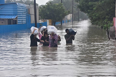 Public wading through a flooded street in Thoothukudi. (Photo | V Karthik Alagu, EPS)