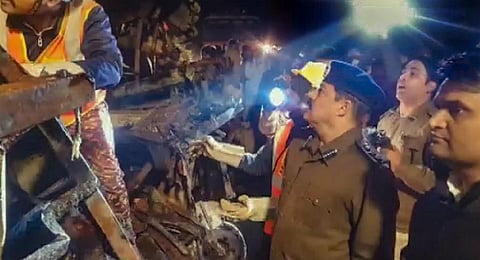 Police officials inspect a site where a bus caught fire after colliding with a dumper, in Guna district. (Photo | PTI)