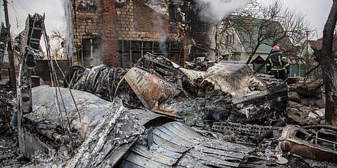 A Ukrainian firefighter walks between at fragments of a downed aircraft seen in in Kyiv, Ukraine, Friday, Feb. 25, 2022. (File Photo | AP)