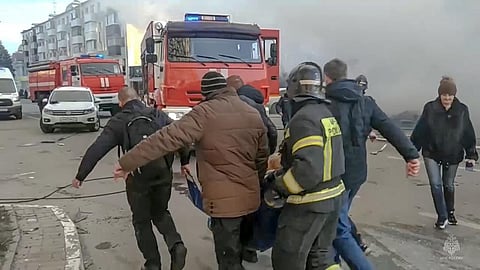 Rescuers and people carry a wounded person after shelling in Belgorod, Russia, on 30 Dec 2023 | AP