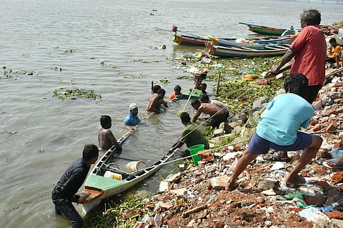 Fishermen trying to recover an overturned boat at Gollapudi near Vijayawada on Wednesday. (Prasant Madugula)