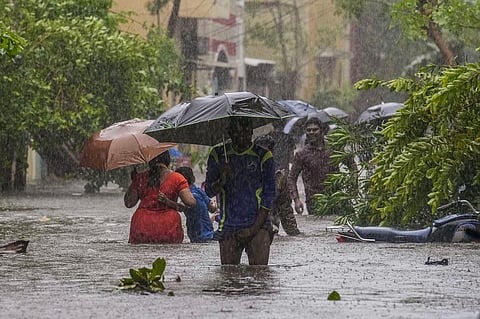 FILE: People wade through a flooded road after heavy rainfall owing to Cyclone Michaung, in Chennai, Tuesday, Dec. 5, 2023. (Photo | PTI)